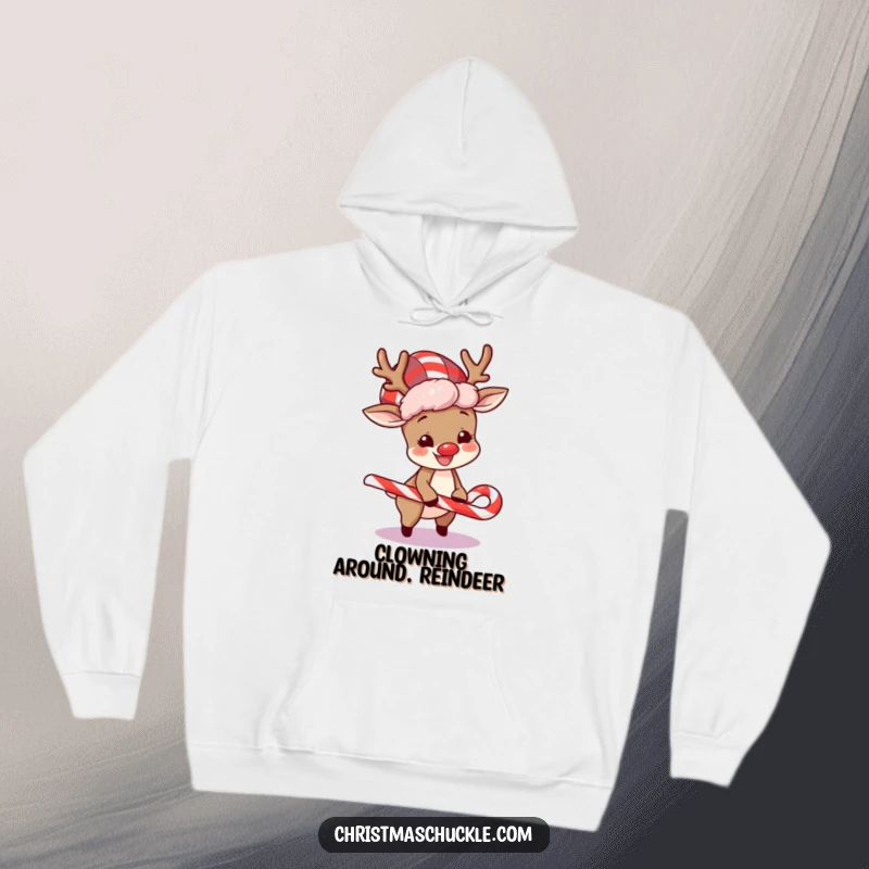 Funny hoodie showcasing a happy reindeer sporting a clown wig, comically tripping over a candy cane in a festive scene.