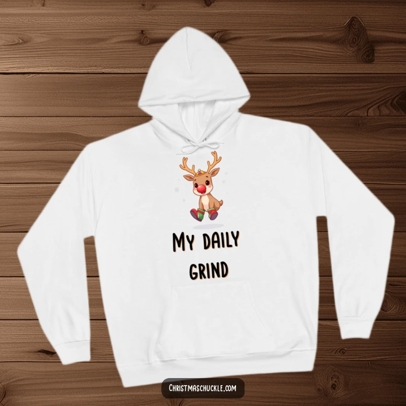 Funny hoodie depicting a cute reindeer dressed as a clown, juggling snowflakes with oversized shoes and a red nose, ready for winter fun.