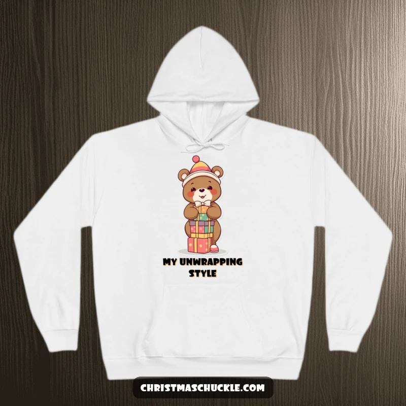 Funny hoodie featuring a smiling bear in a clown suit, precariously balancing presents, ideal for festive comfort and humorous style.