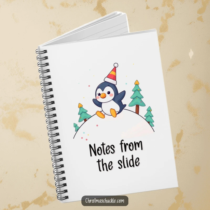 Funny notebook cover with a cheerful penguin character with a clown nose, joyfully sliding down a festive hill, ideal for notes.