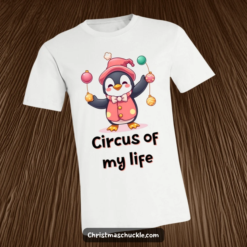 Funny t-shirt with a cute penguin character in a clown suit, juggling colorful baubles, perfect for festive celebrations and humor.