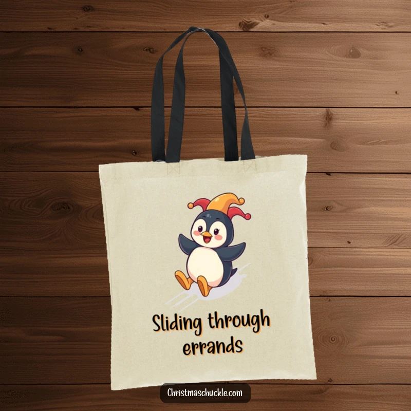 Funny penguin clown tote bag with a cheerful penguin sliding down a festive hill wearing a clown nose.